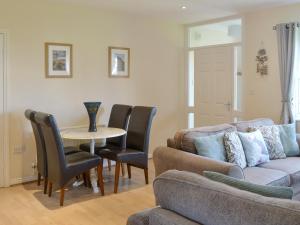 a living room with a couch and a table and chairs at Sandpiper in Beadnell