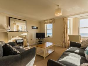 a living room with a couch and a fireplace at 13 Great Cliff in Dawlish