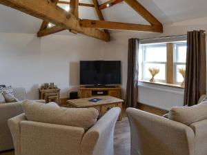 a living room with a tv and a couch and chairs at Greengill Farm Holiday Cottage - Ukc2768 in Gilcrux