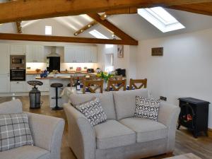 a living room with two couches and a kitchen at Greengill Farm Holiday Cottage - Ukc2768 in Gilcrux