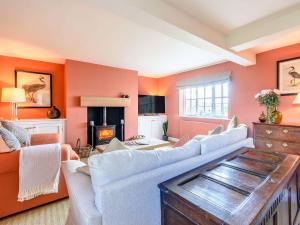 uma sala de estar com paredes e sofás cor-de-laranja e uma lareira em Limber Wold House em Great Limber