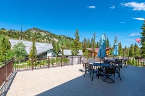 a patio with tables and chairs and a fence at Brighton Chalet Utah Entire 9 Bedroom House in Brighton