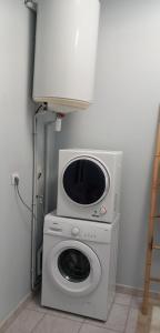 a washing machine with a microwave on top of it at Studio pratique, Garage gratuit, Esprit Auber in Béziers