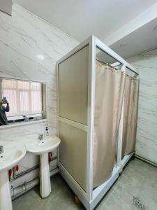 een badkamer met een douche en een wastafel bij Hostel Akacia in Simkent