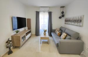 a living room with a couch and a flat screen tv at M&D Centro Málaga in Málaga