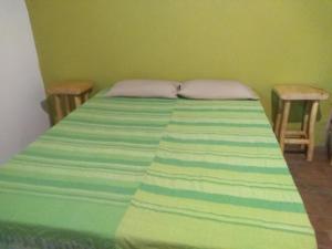 a green bedroom with a bed with two chairs at Casa alma verde alegría y paz in Luyaba