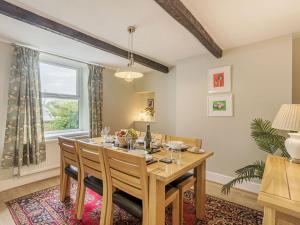 ein Esszimmer mit einem Holztisch und einem Fenster in der Unterkunft Lane Ends Cottage in Disley