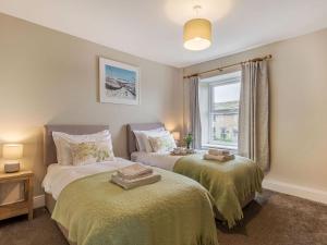 a bedroom with two beds and a window at Lane Ends Cottage in Disley