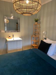 Schlafzimmer mit einem Bett, einem Waschbecken und einem Spiegel in der Unterkunft Family bungalow with garden for 6-8 people in Cadzand