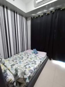 a bed in a room with a black curtain at SEA RESIDENCES Yeshua in Manila