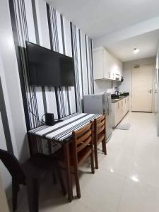 a kitchen with a table with a television on it at SEA RESIDENCES Yeshua in Manila