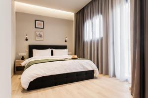 um quarto com uma cama grande e uma janela em WYZ Piraeus em Piraeus