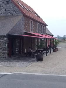 un edificio in mattoni con tavoli da picnic all'esterno di Le Marquis De La Guintre a Courtils