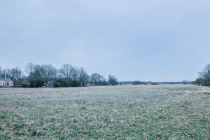 a large field of grass with a house in the background at WOHNWAGON Tiny Houses II in Gutenstein