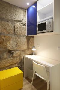 cocina con mesa blanca y microondas en FLH Porto Downtown GuestHouse, en Oporto