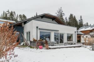 una pequeña casa blanca en la nieve con árboles en QUARTIER 179, en Schladming