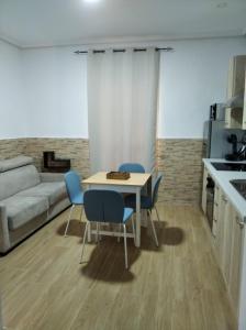sala de estar con mesa, sillas y sofá en Apartamento Playa La Caleta en Cádiz