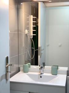 ein Bad mit einem Waschbecken und einem Spiegel in der Unterkunft Pérola de Gil Vicente Duplex in Setúbal