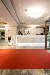 ストックホルムにあるLivington Hotelの赤い絨毯とカウンター付きのロビー