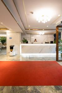 a lobby with a red carpet and a counter at Livington Hotel in Stockholm