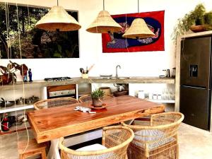 a kitchen with a wooden table and chairs at Hakha Beach House in Praia do Tofo