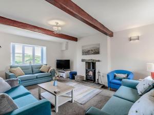 a living room with blue couches and a fireplace at Middle Bank Top Farm - Uk39183 in Rossendale