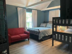 ein Schlafzimmer mit einem Bett und einem roten Stuhl in der Unterkunft Updated Red Door Revival in Downtown Saint Augustine in St. Augustine