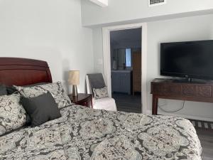 a bedroom with a bed and a flat screen tv at Updated Red Door Revival in Downtown Saint Augustine in St. Augustine