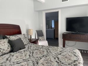 a bedroom with a bed and a flat screen tv at Updated Red Door Revival in Downtown Saint Augustine in Saint Augustine