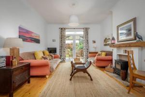 ein Wohnzimmer mit orangefarbenen Möbeln und einem Kamin in der Unterkunft Heather Cottage, 2 bedroom in Comrie in Comrie