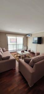 Sala de estar con 2 sofás y mesa en Departamento Caseros Salta en Salta