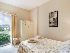 a bedroom with a bed and a large window at Homewood in Far Sawrey