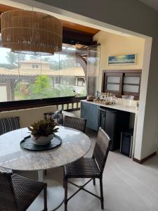 a kitchen and dining room with a table and chairs at Praia do Forte Condomínio Bali Bahia Apt105 in Praia do Forte