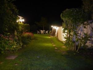 un jardín nocturno con mesa y sillas en Maisonnette Rambouillet, en Rambouillet