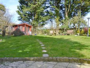 a grassy yard with a house in the background at The Bridge Inn Apartment in Bridgerule