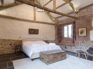 a bedroom with a bed and a brick wall at The Bothy - UKC3549 in Holcombe Burnell