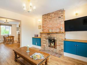 a living room with a brick fireplace and a tv at Stonegarth in Snitterby