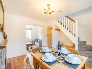 a dining room with a table and chairs and a staircase at Stonegarth in Snitterby