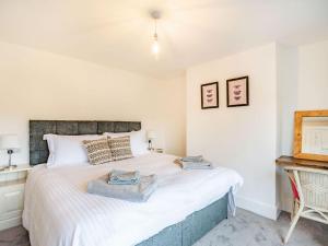 um quarto com uma grande cama branca num quarto em Stonegarth em Snitterby