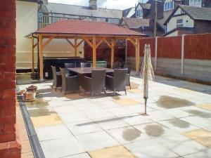 a gazebo with a table and chairs on a patio at Heritage Lodge in Rhyl