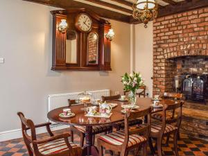 a dining room with a table and a clock on the wall at Heritage Lodge in Rhyl