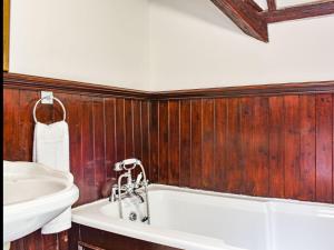 a bathroom with a bath tub and a sink at Heritage Lodge in Rhyl