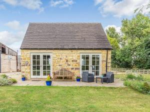 a stone cottage with two chairs and a table at Little Barn in Shirland