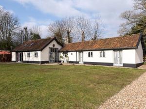 an old white barn with a large yard at The Old Hall Coach House in Ashwellthorpe