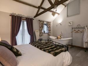 a bedroom with a bed and a tub and a sink at The Old Hall Coach House in Ashwellthorpe