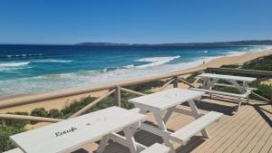 two picnic tables on a deck overlooking the beach at 128 @ The Dunes in Plettenberg Bay