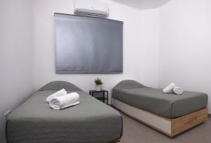 1 dormitorio con 2 camas y pantalla de proyección en Lovely 2 Bed Apartment in Larnaca City Centre, en Lárnaca