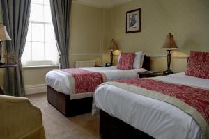 a hotel room with two beds and a window at Old Hunstanton Le Strange Arms Hotel in Hunstanton