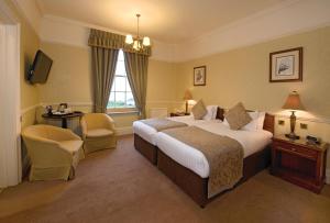 a hotel room with a large bed and a window at Old Hunstanton Le Strange Arms Hotel in Hunstanton