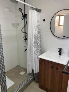 bagno con doccia, lavandino e specchio di Casa mediterránea Villamar Guanaqueros a Guanaqueros